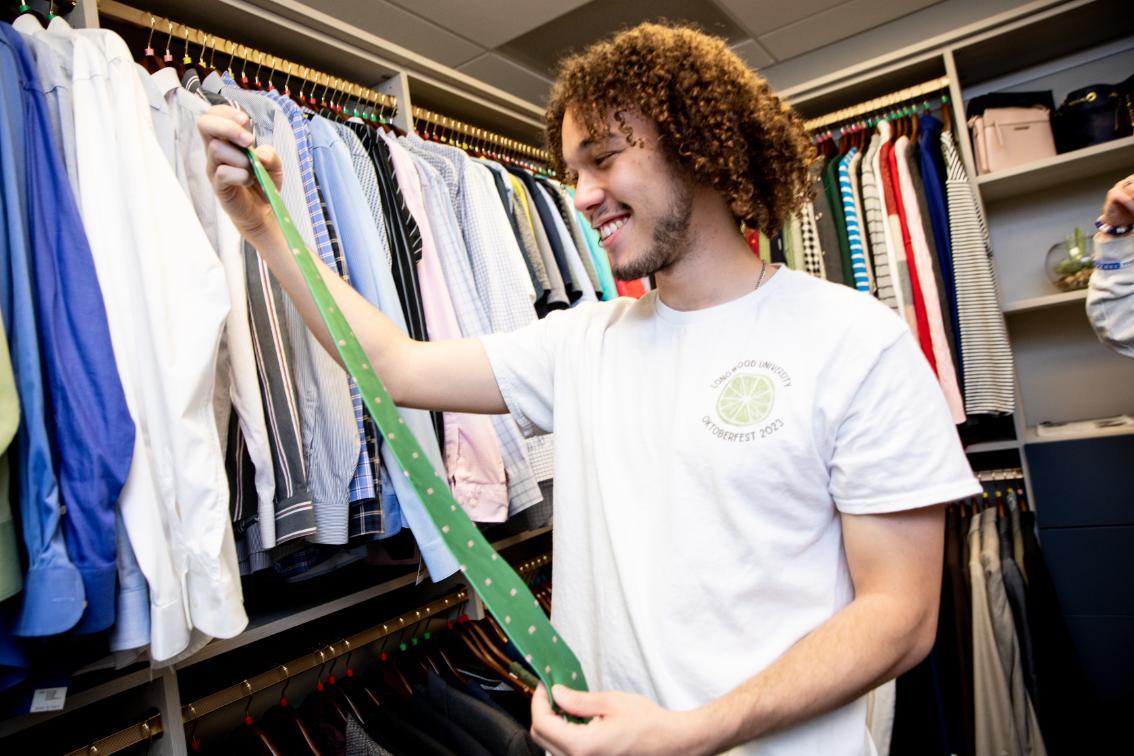 Student looking at a tie in the Career Closet