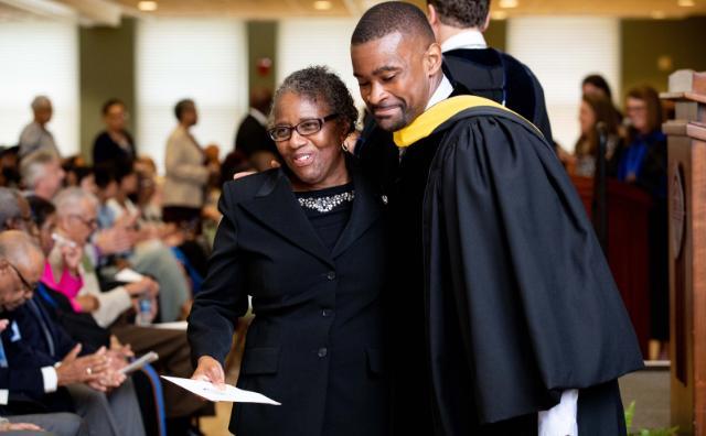 School lockout victim Sherry Brown greets Moton Museum Executive Director Cainan Townsend after walking across the front of the stage and receiving her honorary diploma on Sunday.