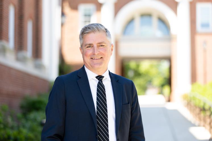 Dr. Wade Edwards, the newly-appointed Dean of the Cook-Cole College of Arts and Sciences stands outside, with the Allen Hall breezeway in the background.